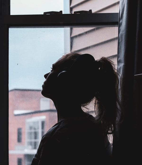 Person in a calm, focused state after a workout, looking out a window.